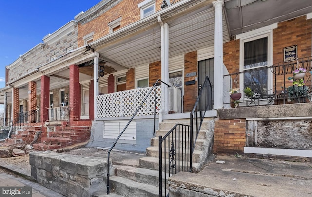 view of front of house with covered porch and brick siding