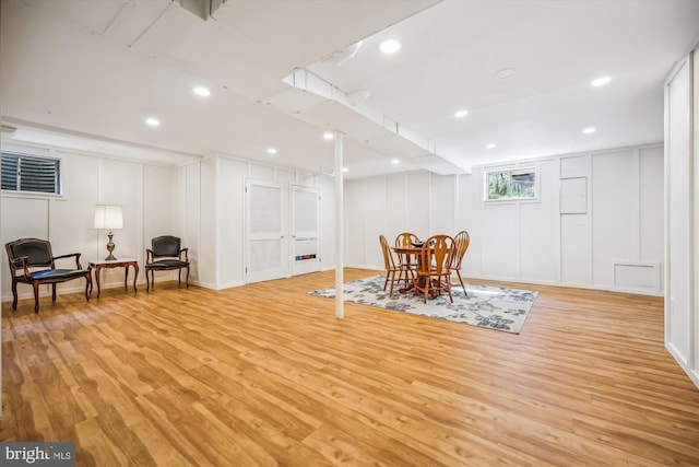 dining room featuring a decorative wall, light wood finished floors, and recessed lighting