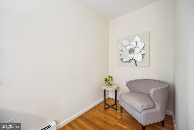 living area with wood finished floors, baseboards, and a baseboard radiator