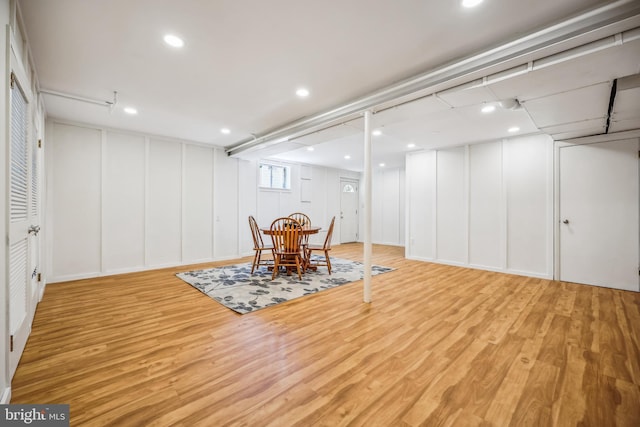 dining space with a decorative wall and wood finished floors