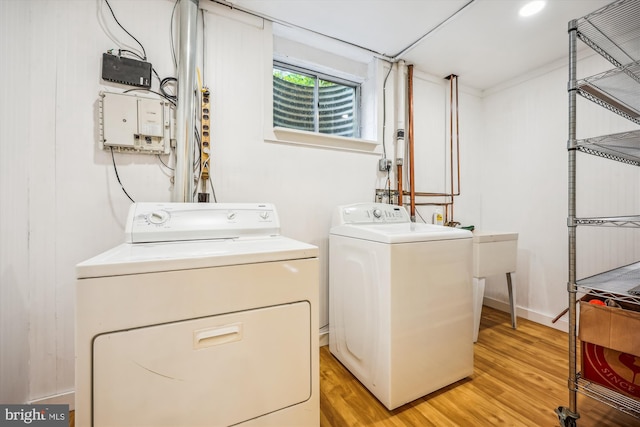 laundry area featuring independent washer and dryer and light wood finished floors