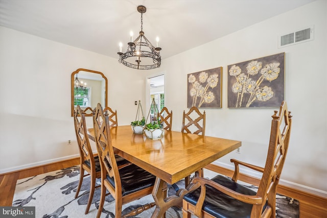 dining area featuring a chandelier, baseboards, wood finished floors, and plenty of natural light