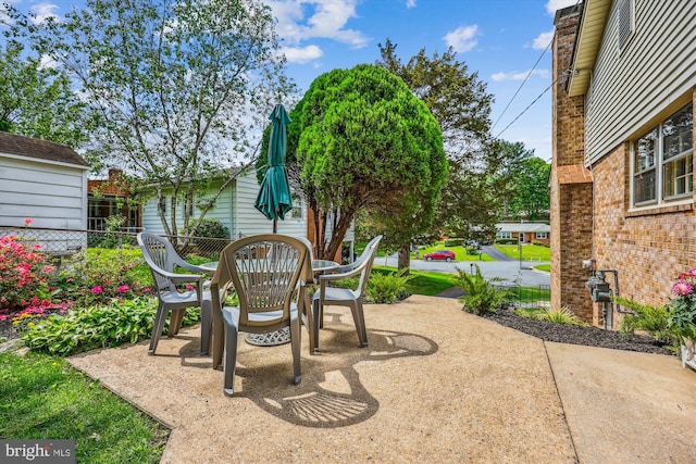 view of patio with outdoor dining area and fence