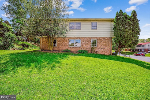 view of front of property with a front lawn and brick siding