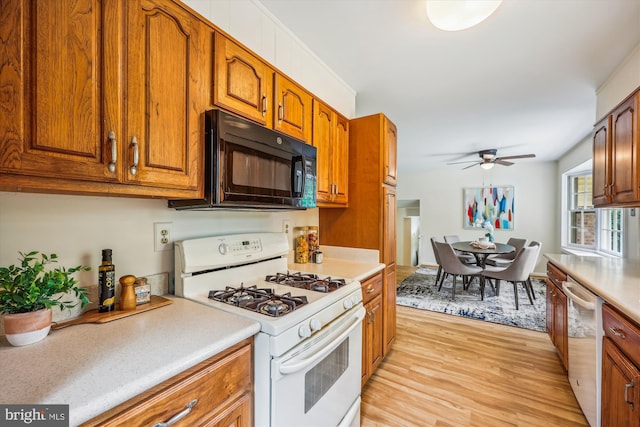 kitchen with white gas range oven, black microwave, dishwashing machine, light wood-type flooring, and brown cabinetry