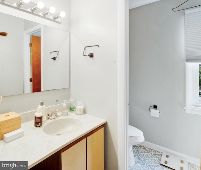 half bath with vanity, baseboards, and toilet