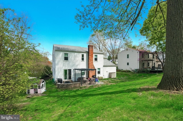 back of house featuring a lawn, a patio, and a chimney