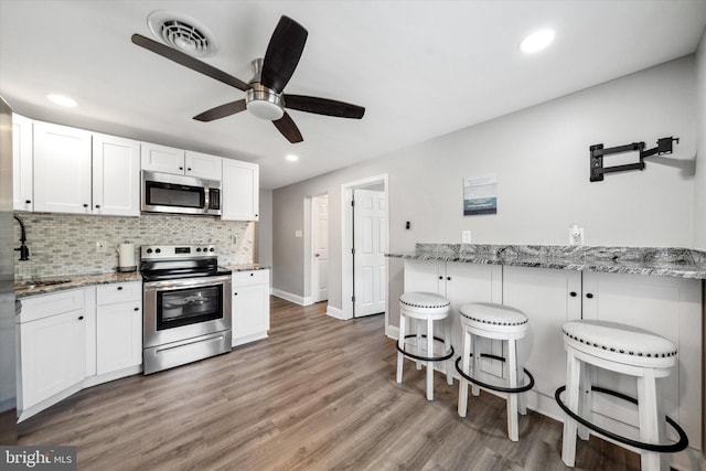 2304 Milltown Rd, Wilmington, DE 19808 - kitchen featuring a ceiling fan, visible vents, light wood-type flooring, a breakfast bar, and stainless steel appliances