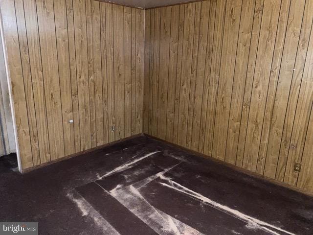 spare room featuring wood walls