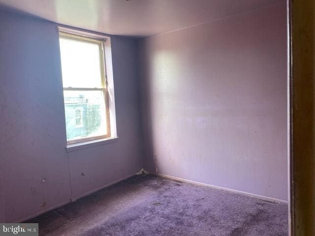 carpeted spare room with baseboards
