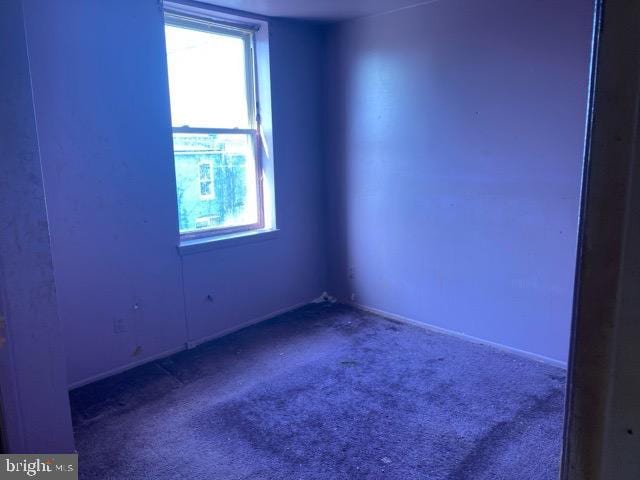 carpeted spare room featuring baseboards