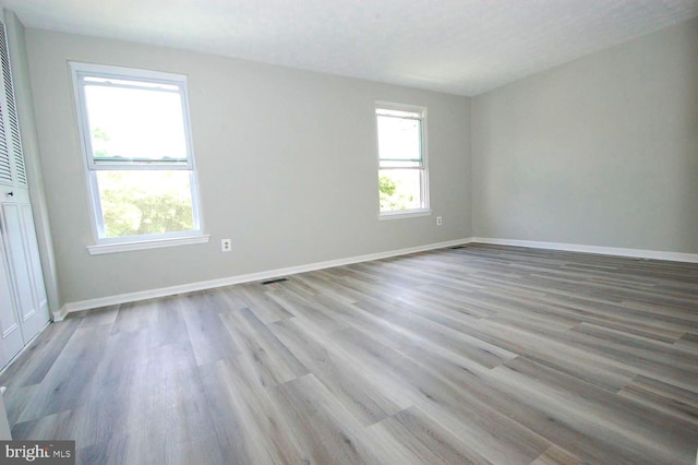 unfurnished room featuring baseboards and light wood finished floors