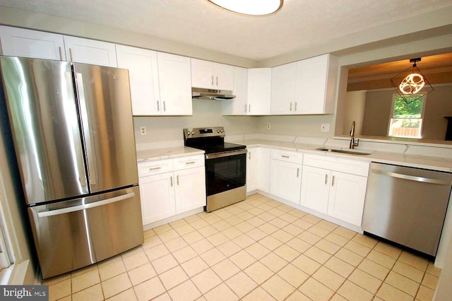 kitchen with light tile patterned flooring, a sink, stainless steel appliances, white cabinetry, and under cabinet range hood