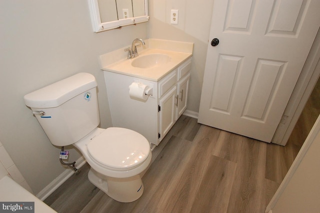bathroom with vanity, baseboards, wood finished floors, and toilet