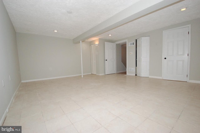 interior space with recessed lighting, a textured ceiling, visible vents, and baseboards