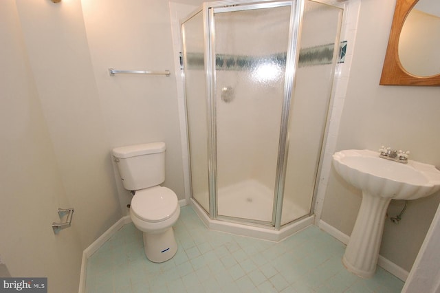 full bathroom with toilet, baseboards, tile patterned floors, a sink, and a stall shower