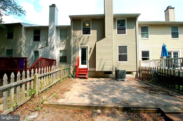 rear view of house with cooling unit, a patio area, a chimney, and entry steps