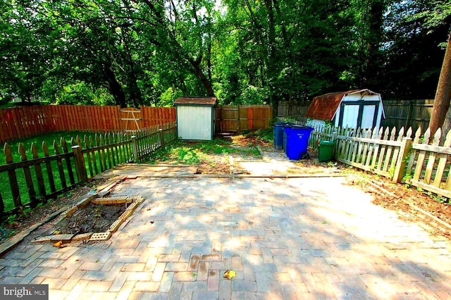 view of patio with a storage shed, an outbuilding, and a fenced backyard