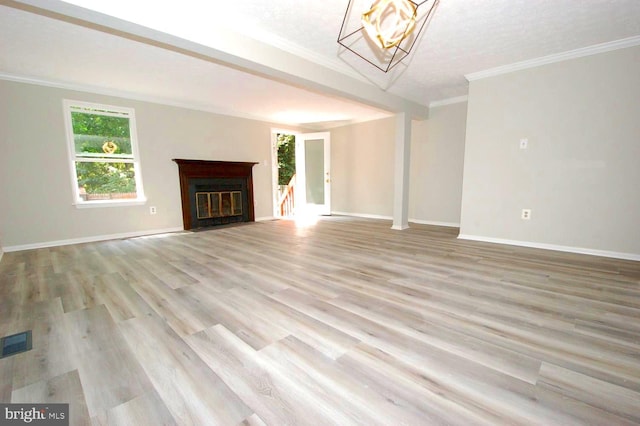 unfurnished living room with crown molding, light wood-style floors, baseboards, a fireplace with flush hearth, and visible vents