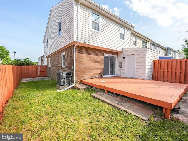 rear view of property featuring a fenced backyard, central AC unit, a lawn, and a wooden deck
