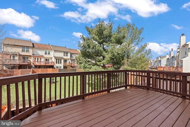 wooden deck with fence, a yard, and a residential view