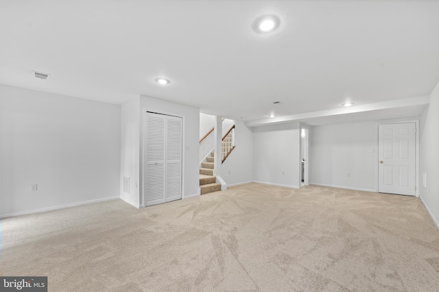 finished basement featuring carpet floors, recessed lighting, stairs, and visible vents
