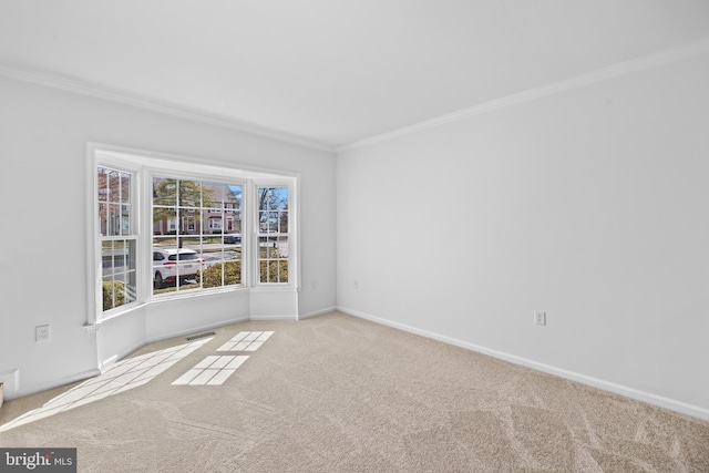 unfurnished room with baseboards, ornamental molding, carpet flooring, and visible vents