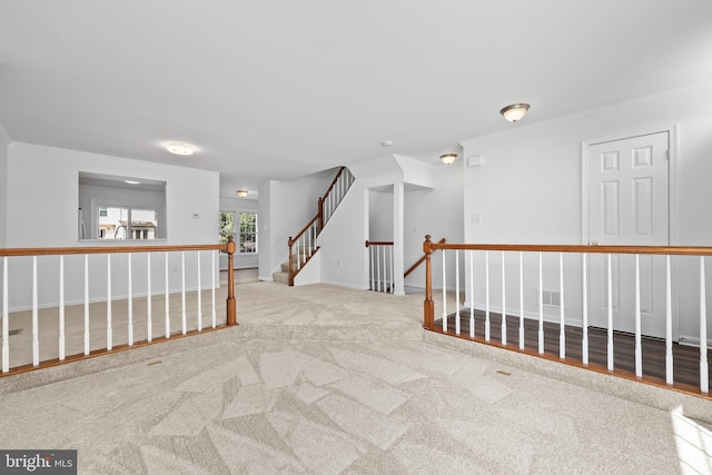 hallway featuring crown molding, baseboards, visible vents, and carpet