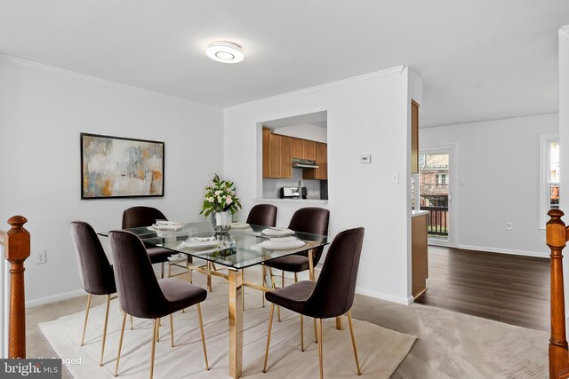 dining area featuring crown molding and baseboards