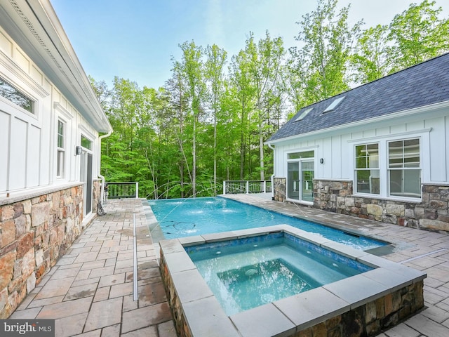 pool featuring an in ground hot tub and a patio area