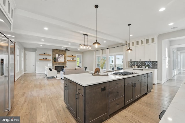 kitchen with dark brown cabinetry, appliances with stainless steel finishes, light countertops, light wood finished floors, and white cabinetry
