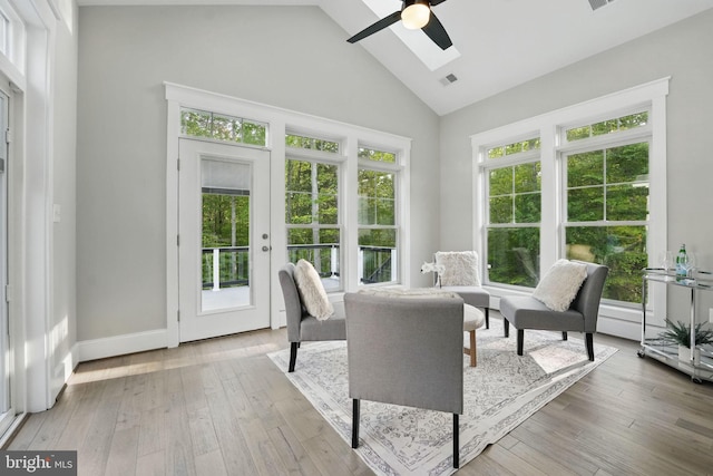 sunroom with french doors, visible vents, a skylight, a wooden deck, and high vaulted ceiling