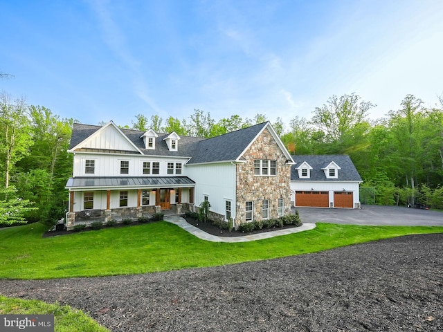 view of front of house featuring covered porch, a standing seam roof, metal roof, an outbuilding, and stone siding