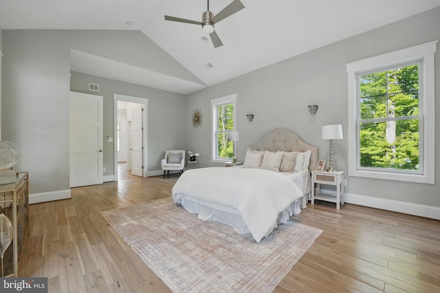 bedroom featuring visible vents, baseboards, vaulted ceiling, and light wood-type flooring