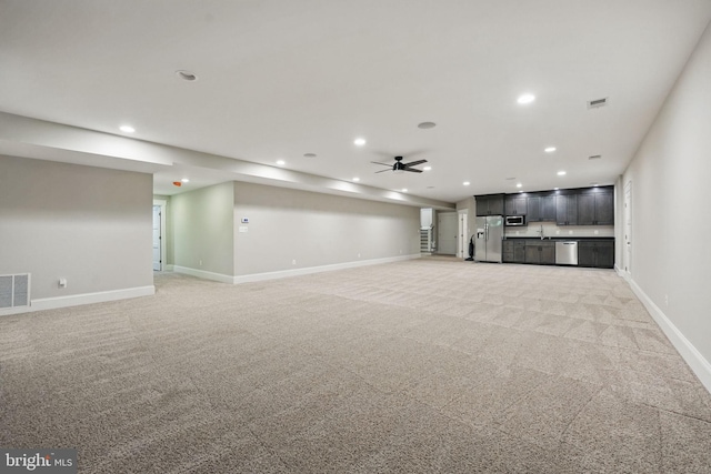 unfurnished living room featuring baseboards, ceiling fan, recessed lighting, and light colored carpet