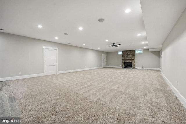 unfurnished living room featuring a large fireplace, baseboards, and recessed lighting