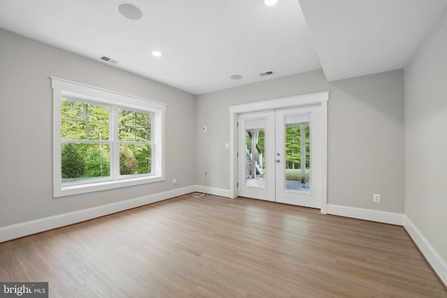 unfurnished room featuring baseboards, visible vents, french doors, and light wood-type flooring