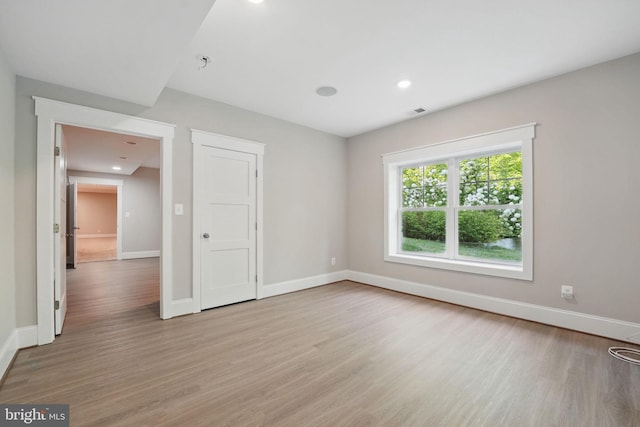 empty room with baseboards, recessed lighting, light wood-style flooring, and visible vents