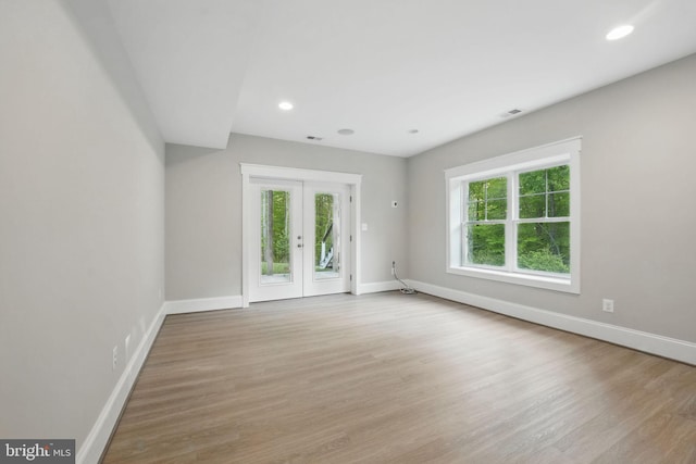 unfurnished living room featuring baseboards, french doors, wood finished floors, and visible vents