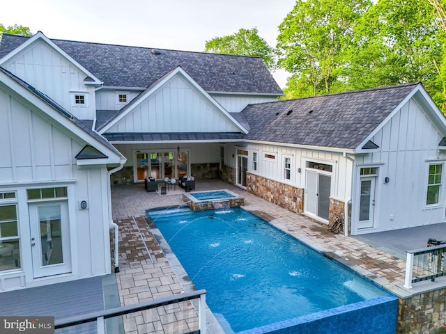 view of pool featuring a patio area, a pool with connected hot tub, and french doors