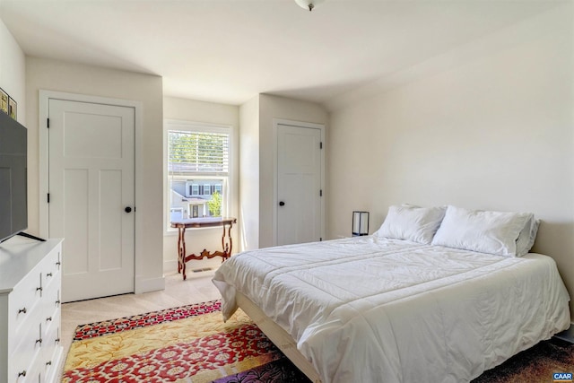 bedroom featuring baseboards and light colored carpet
