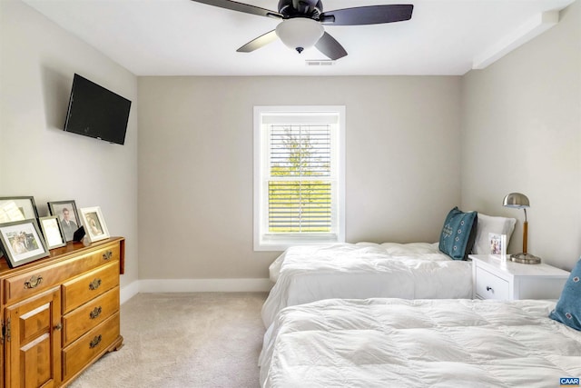 bedroom featuring baseboards, a ceiling fan, visible vents, and light carpet