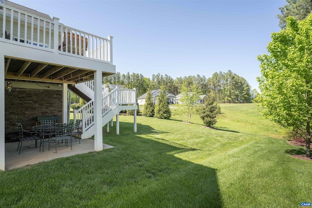 view of yard with a deck, stairs, and a patio area