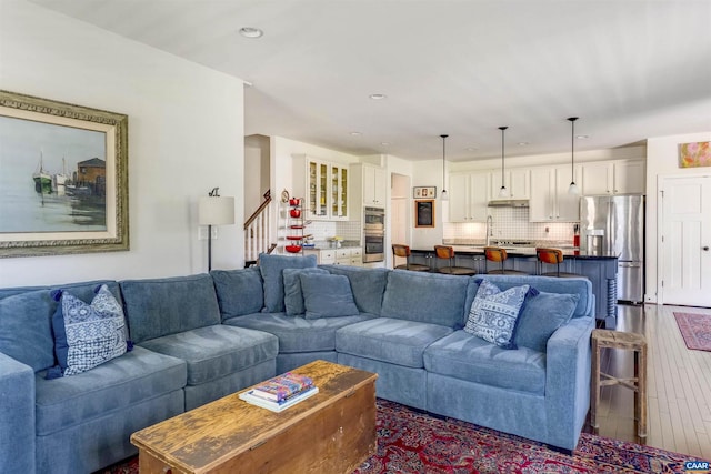 living area featuring recessed lighting, stairs, and wood finished floors