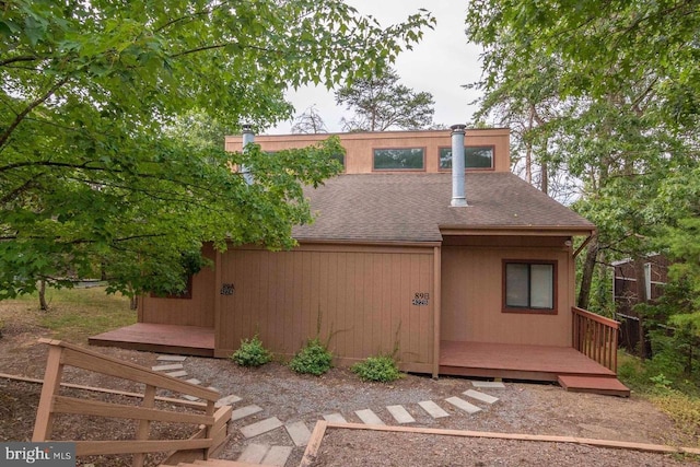 back of house with a shingled roof and a wooden deck