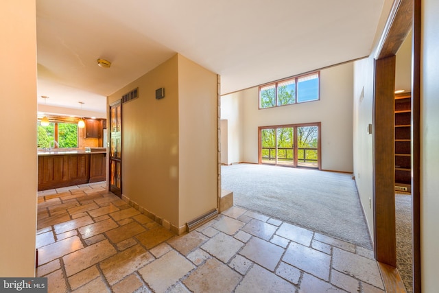 unfurnished room featuring baseboards, visible vents, and stone tile flooring
