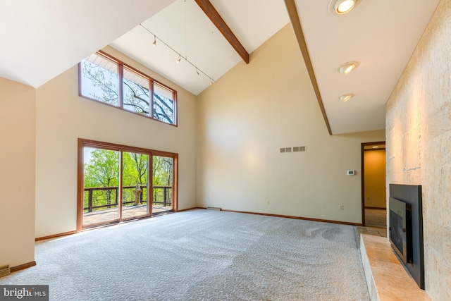 unfurnished living room with high vaulted ceiling, a fireplace, light colored carpet, and visible vents