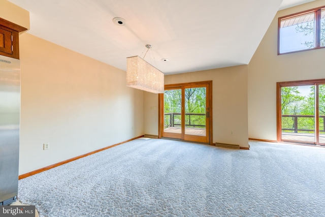 carpeted empty room featuring a healthy amount of sunlight and baseboards
