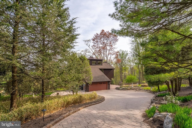 view of home's community with decorative driveway
