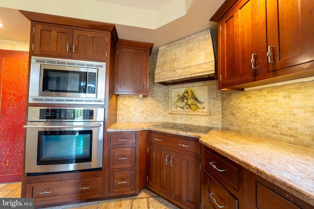 kitchen featuring backsplash, stainless steel appliances, light stone counters, and custom range hood